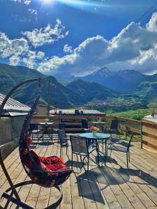 d'une terrasse avec une table, des chaises et des montagnes. dans l'établissement Guesthouse Elia, à Kazbegi