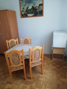 a dining room table and chairs with a table and a refrigerator at U Halinki in Darłowo
