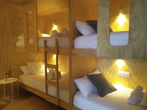 a room with three bunk beds and a mirror at Area Surf House in Muros