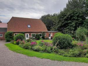 a house with a garden in front of it at Landhof Osterdeich in Emmelsbüll-Horsbüll