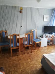 a dining room with a table and chairs and a television at U Halinki in Darłowo