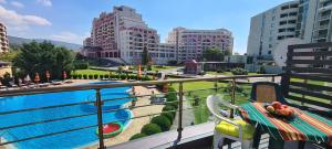 balcón con mesa y vistas a la piscina en Menada Sunny Beach Plaza Apartments, en Sunny Beach