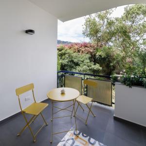 een kamer met een tafel en 2 stoelen op een balkon bij Akyra suites in Sorrento