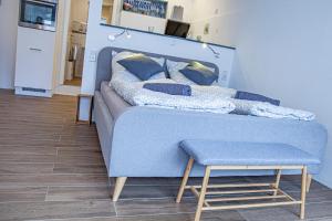 a blue couch with pillows and a stool in a room at Apartment Moseltraum in Zell an der Mosel