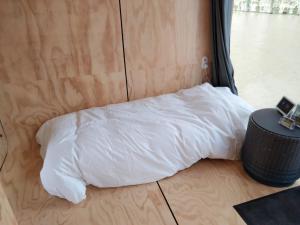 a white pillow sitting on the floor of a room at Wikkelboats @ Tramkade Den Bosch in Orthen