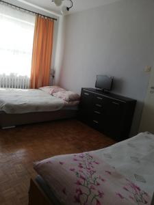 a bedroom with two beds and a laptop on a dresser at U Halinki in Darłowo