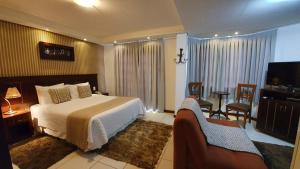 um quarto de hotel com uma cama e uma televisão em Pousada Cheverny - Fácil acesso ao centrinho e Baden Bar em Campos do Jordão