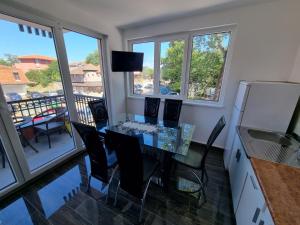 a dining room with a glass table and chairs at Apartmani SIMIC Lux Srebrno Jezero in Kisiljevo