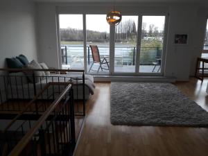 a living room with a couch and a large window at Wohnen am Wasser in Wiesbaden