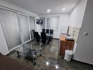 an office with a glass table and black chairs at Apartmani SIMIC Lux Srebrno Jezero in Kisiljevo