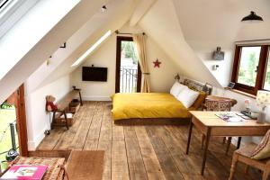 een slaapkamer met een geel bed op een zolder bij The Roost in Semley