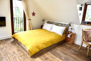 um quarto com uma cama com um cobertor amarelo em The Roost em Semley