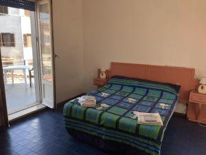 Blu Mare Villa Carlo في أنزيو: غرفة نوم بسرير وباب زجاجي منزلق