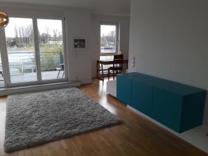 a living room with a blue dresser and a table at Wohnen am Wasser in Wiesbaden