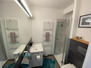 a bathroom with a sink and a shower and a toilet at City-Apartment Dülmen in Dülmen