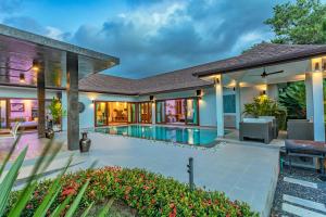 a house with a swimming pool and a patio at Bangtao Boutique Villa in Bang Tao Beach