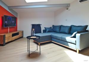 - un salon avec un canapé bleu et une table dans l'établissement T2 chaleureux au centre de castelnaudary, à Castelnaudary