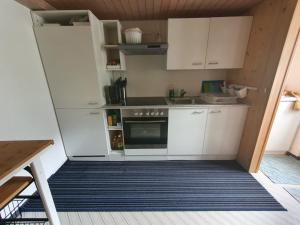 a kitchen with white cabinets and a stove at Apartment Lilalama in Grindelwald