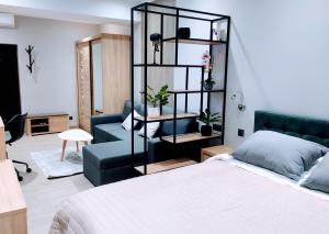 a bedroom with a bed and a blue couch at AVENUE APARTMENTS-Hermes in Chişinău