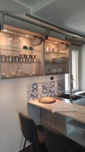 La Terra Buona guest house في Villa San Secondo: مطبخ مع كونتر وكراسي في غرفة