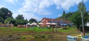 a house with umbrellas on the side of a river at Kappoleni - ein Boot für dich in Lauenburg