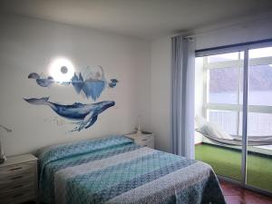 Un dormitorio con una cama azul y una ventana. en Apartment on the sea, en Puerto de la Madera