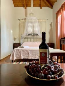 a bottle of wine and a plate of grapes on a table at Serenita Villa in Zakynthos