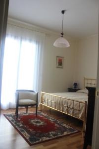 a bedroom with a bed and a chair and a window at B&B Julia in Gallipoli