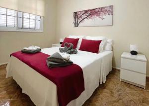 a bedroom with a large white bed with red pillows at Soyemar Playa Apartments in Santa Cruz de Tenerife
