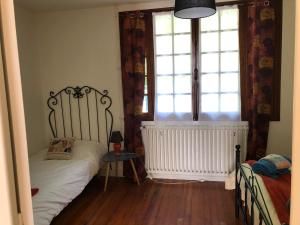 een kleine slaapkamer met een bed en een raam bij Chez FIRMIN "Les Ombrages" in Mesnac