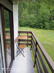 weranda z drewnianym stołem i ławką w obiekcie Apartma Aurora w mieście Kranjska Gora +1 zdjęcie