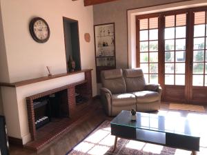 Chez FIRMIN "Les Ombrages" في Mesnac: غرفة معيشة مع أريكة ومدفأة