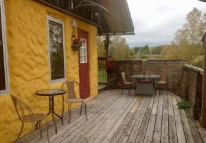 un patio con mesa y sillas en una terraza de madera en Lanthotellet Hishult en Hishult