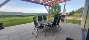 a table and chairs on a patio with a fireplace at Panorama house Brdy in Příbram