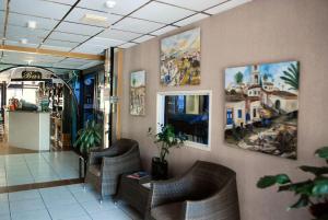 a lobby with chairs and paintings on the walls at San Remo Hotel in Larnaca