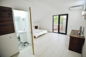 a white room with a bed and a mirror at Vila Medusa in Vama Veche