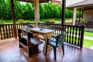 a wooden table and chairs on a porch at Вилен комплекс Дарибел in Sapareva Banya