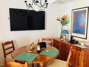 een eetkamer met een tafel en een televisie bij Aquamar in Patalavaca