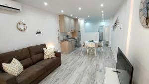 a living room with a brown couch and a kitchen at Mareverde in Adeje