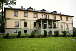 ein großes Haus mit Rasen davor in der Unterkunft Hotel Grasu Pils in Cesvaine