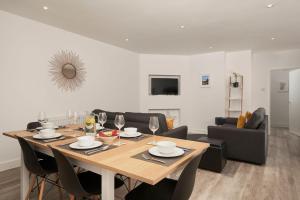 a dining room with a table and a couch at The Parlour - The Cottages at Blackadon Farm in Wrangaton