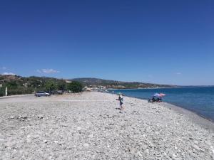 a person standing on a beach with an umbrella at Casa Vacanza Libone in Nova Siri Marina +10 photos