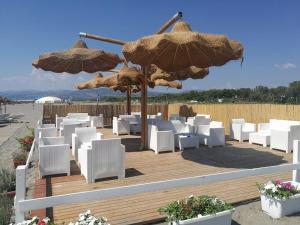 a bunch of chairs and umbrellas on a deck at Casa Vacanza Libone in Nova Siri Marina
