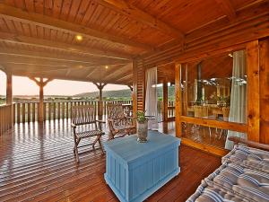 a wooden porch with a couch and chairs on a deck at Reflections Eco-Reserve in Wilderness