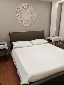 a bedroom with a large white bed with white pillows at Federico 70 Smeraldo in Palermo