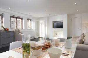 una sala de estar blanca con una mesa con comida. en The Roost - The Cottages at Blackadon Farm, en Ivybridge