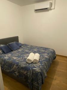 a bedroom with a bed with two towels on it at Appart’hôtel les perles du lac in Tombeboeuf