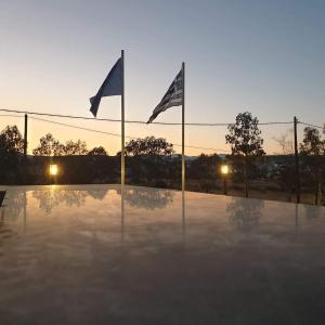 two flags on poles in front of a basketball court at Villa Marelia apartments in Aliveri