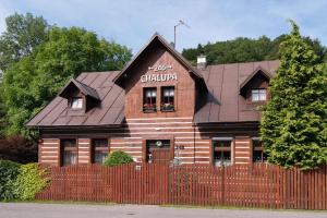 a wooden house with a fence in front of it at Chalupa 246 in Vrchlabí