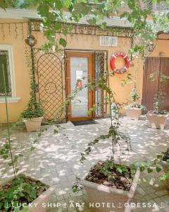 Odessa的住宿－Lucky Ship Art Hotel，庭院里一座有门和植物的房子